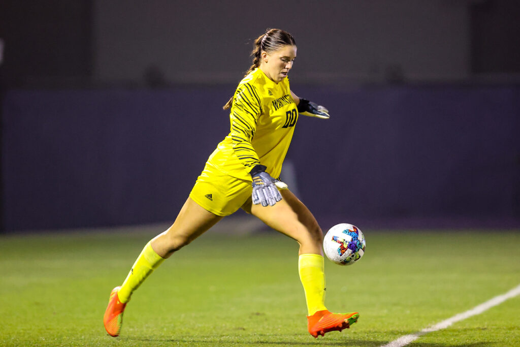 Olivia kicking a ball while playing at University of Washington